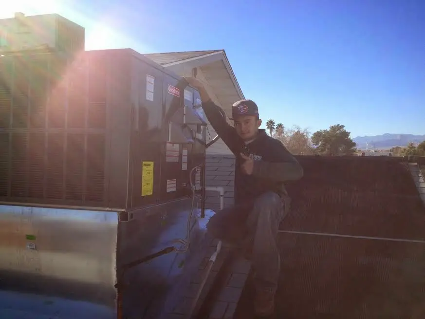 HVAC technician performing Air Duct Repair on a rooftop unit in Burley